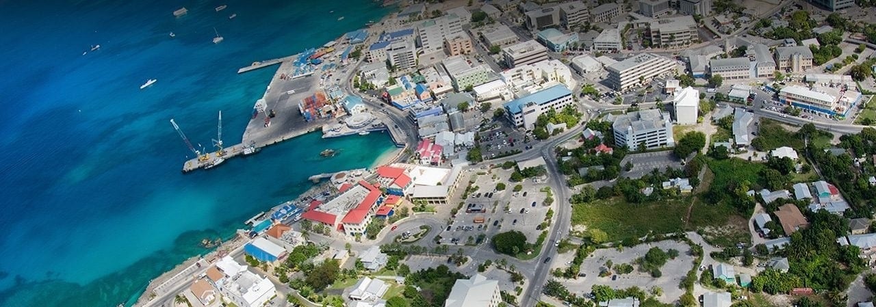 This is an aerial photo of the docks of Georgetown, the capital of the Cayman Islands. On this page you can read about the legal status of games of chance, online wagering, poker, lottery, poker, bingo, cryptocurrency wagering in the Cayman Islands.