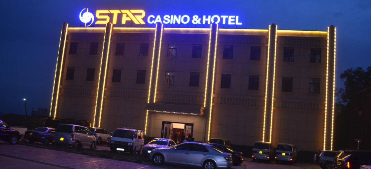 This photo of building and neon sign of Star Hotel And Casino in Kampala, the capital of the Republic of Uganda. Under the picture, on this page, you can read about the legal status of the various forms of Uganda games of chance: internet lottery, digital bingo, electronic poker, sports betting, crypto wagering. There is also info about illegal gambling, betting on blood sports, the licensing system, taxation regime, and you can find a list of licensed online gambling websites, which accept Ugandan players.