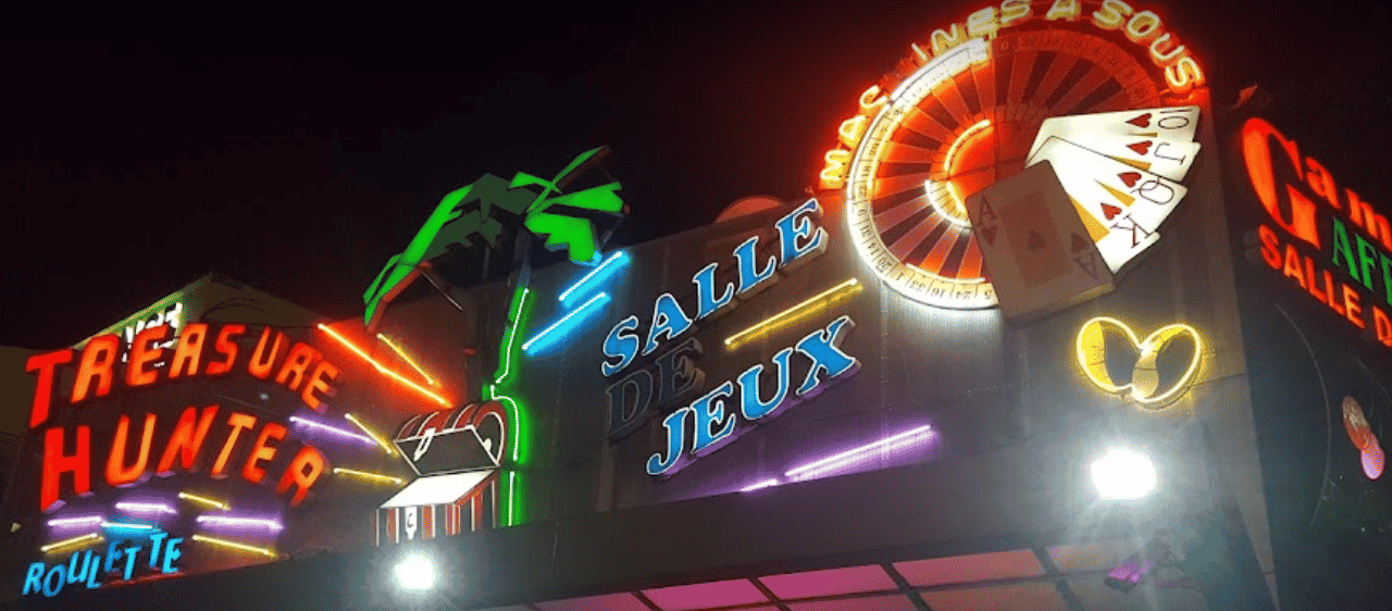 This a photo of the neon sign of Treasure Hunter casino in Douala, the biggest city of the country. Under the picture, on this page, you can read about the legal status of the various forms of Cameroon games of chance: internet lottery, digital bingo, electronic poker, sports betting, crypto wagering. There is also info about betting on blood sports, the licensing system, and taxation of gambling winnings, and you can find a list of licensed online gambling websites, which accept Cameroonian players.