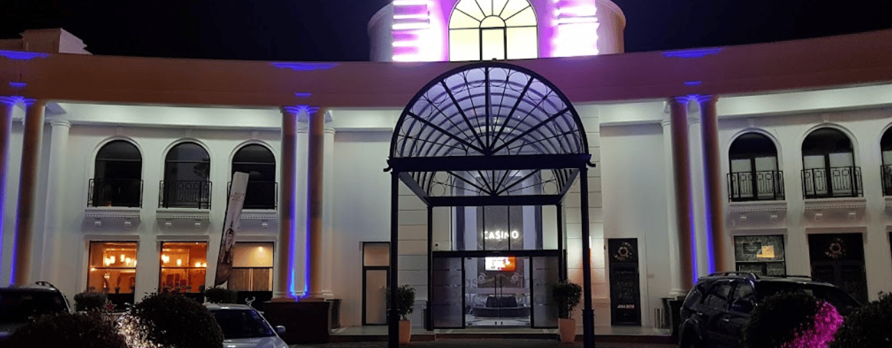 This a photo of the front entrance gate of Casino Polana in Maputo, the capital of the Republic of Mozambique. Under the picture, on this page, you can read about the legal status of the various forms of Mozambique games of chance: internet lottery, digital bingo, electronic poker, sports betting, crypto wagering. There is also info about illegal gambling, betting on blood sports, the licensing system, taxation regime, and you can find a list of licensed online gambling websites, which accept Mozambiquan players.