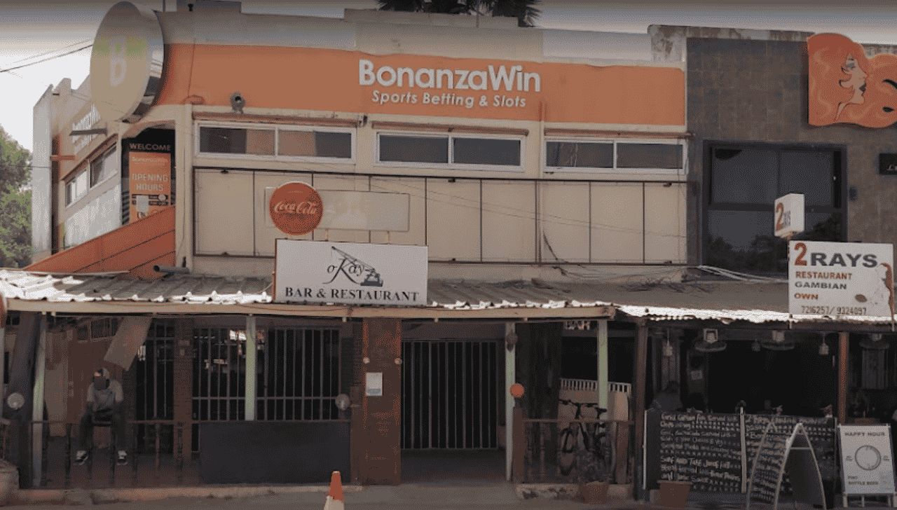 This a photo of the front entrance and facade of the gambling establishment Bonanza Win Sports betting & Slots, in Serrekunda, the biggest city of the Republic of Gambia. Under the picture, on this page, you can read about the legal status of the various forms of Gambia games of chance: internet lottery, digital bingo, electronic poker, sports betting, crypto wagering. There is also info about illegal gambling, betting on blood sports, the licensing system, taxation regime, and you can find a list of licensed online gambling websites, which accept Gambian players.