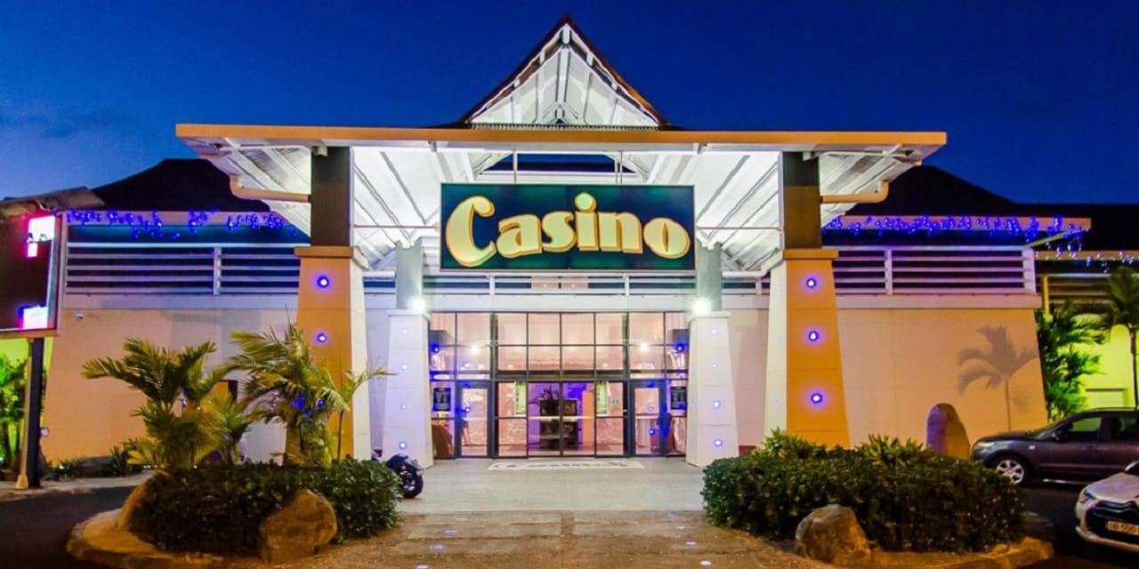 This is a picture of the front facade and main entrance of Casino St. Francois (Saint Francis), the biggest gambling establishments in the Overseas department of Guadeloupe (Département d’Outre-Mer de la Guadeloupe). On this page, you can read about the legislation, rules, licensing, taxation of of the various forms of games of chance and online gambling in the country, including: poker, bingo, lottery, sports betting, cryptocurrency wagering, and a list of online gambling sites which accept players from Guadeloupe.