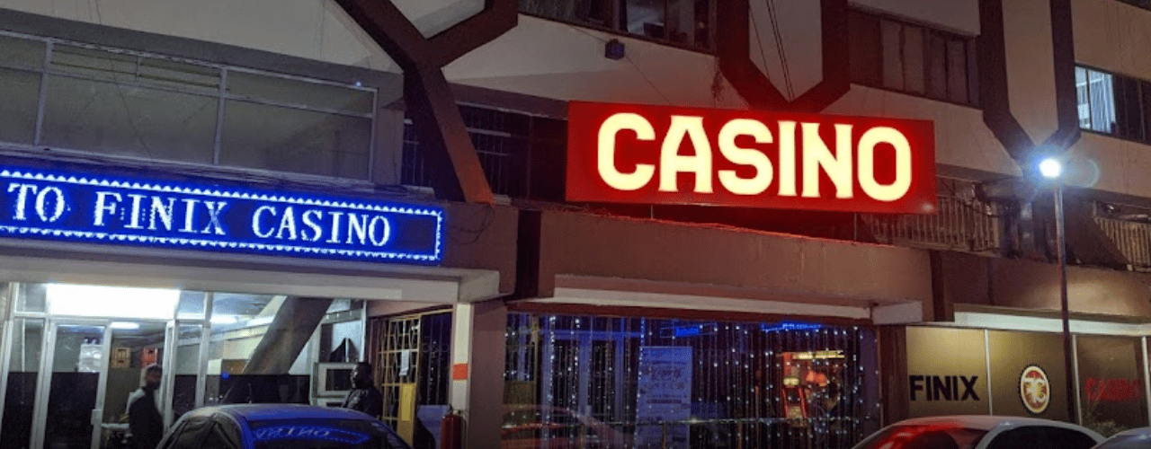 This a photo of the entrance and neon sign of Finix Casino in Nairobi, the capital of the Republic of Kenya. Under the picture, on this page, you can read about the legal status of the various forms of Kenya games of chance: internet lottery, digital bingo, electronic poker, sports betting, crypto wagering. There is also info about illegal gambling, betting on blood sports, the licensing system, taxation regime, and you can find a list of licensed online gambling websites, which accept Kenyan players.